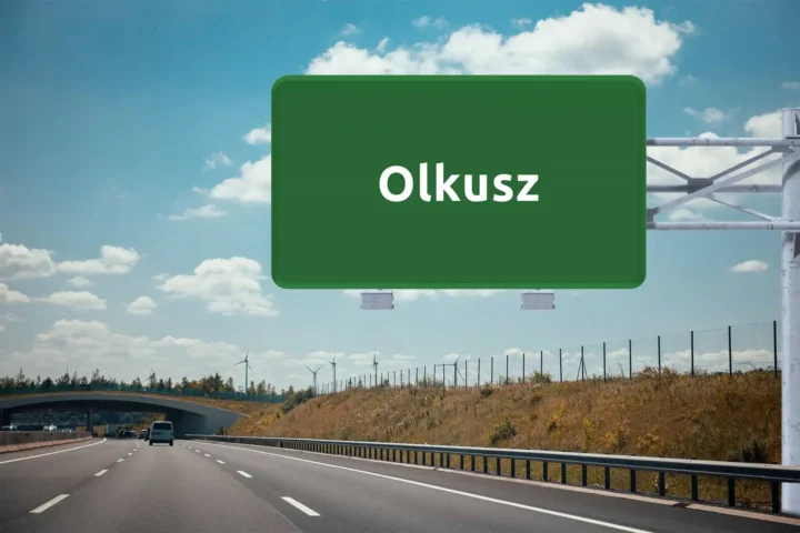 duży, zielony znak drogowy z nazwą Olkusz, wiszący nad autostradą